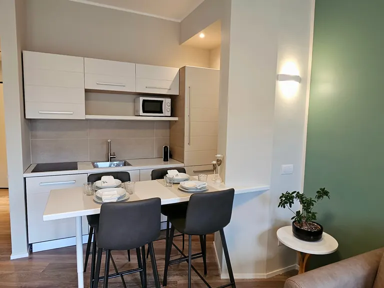 Cucina a vista e tavolo da pranzo per quattro